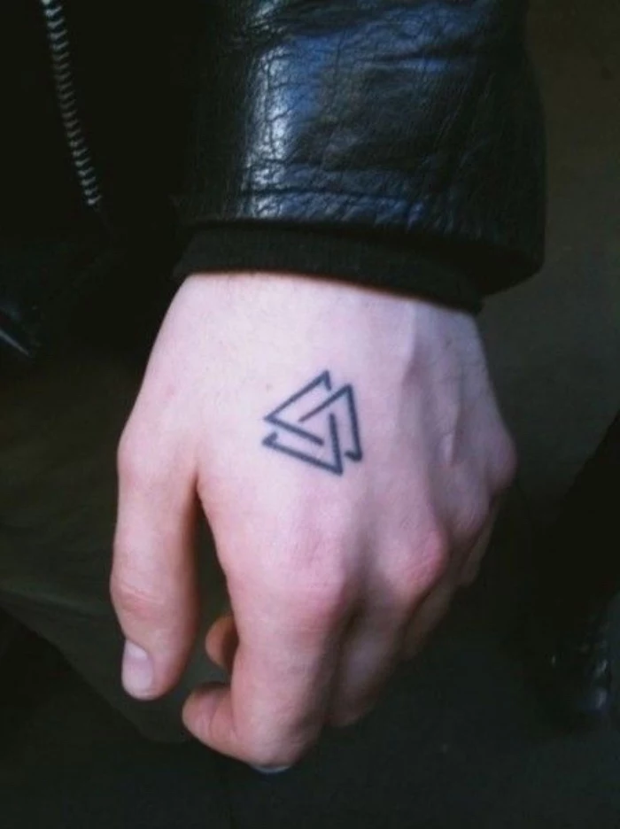 three entwined triangles hand tattoo, small matching tattoos, person wearing a black leather jacket