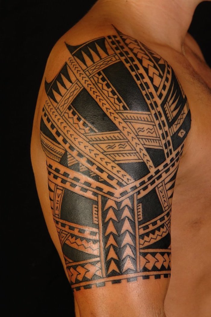 tribal shoulder tattoo, meaningful tattoos, man standing, in front of a black background