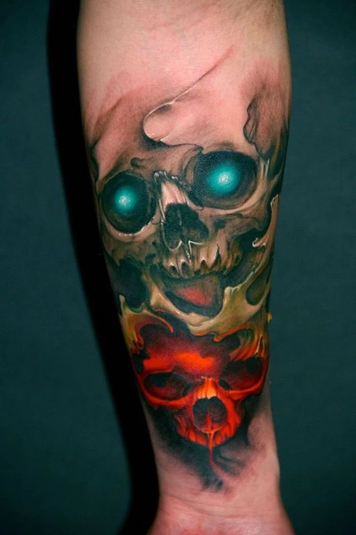 two skulls, colourful forearm tattoo, dark blue background, red and yellow skulls, simple tattoos for men