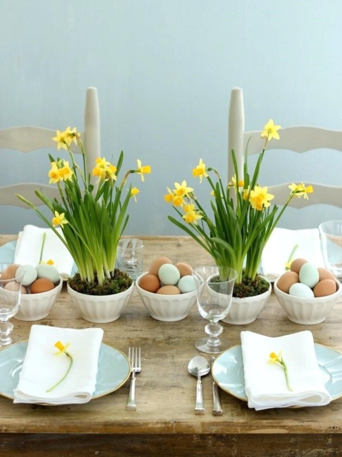 flower bouquets, bowls full of eggs, easter tale centerpieces, blue plates, with white napkins