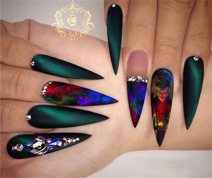 green and black matte nail polish, devil drawings on the nail, manicure ideas, rhinestones on the nails, very long stiletto nails