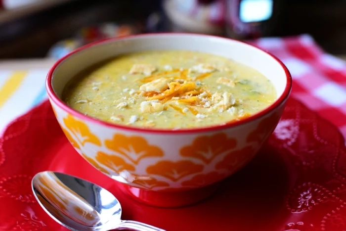 cream soup with carrots, inside a white and orange bowl, on a red plate, healthy eating plan