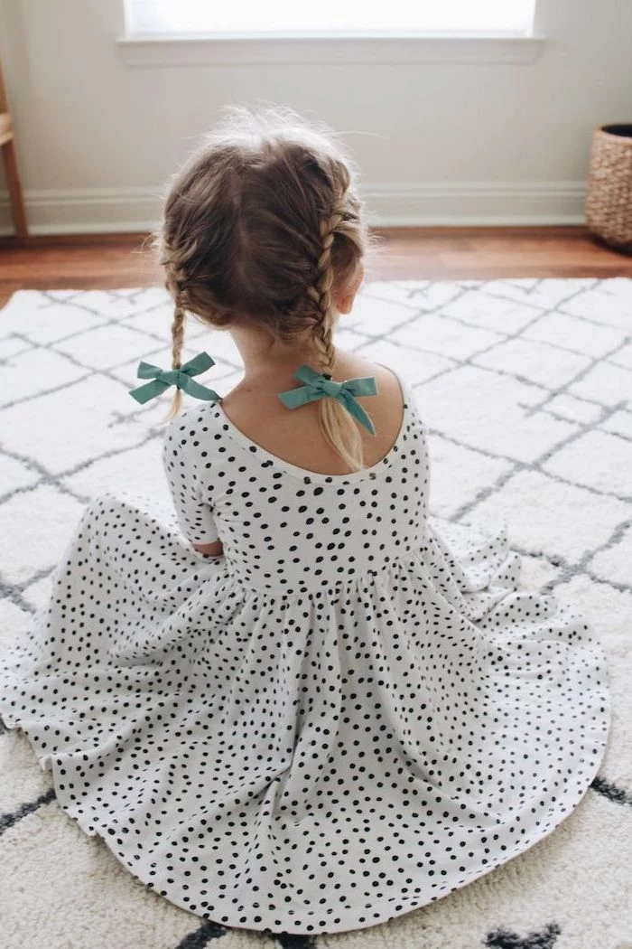 two blue bows, two braids, blonde hair, short hairstyles for little girls, white and black dotted dress