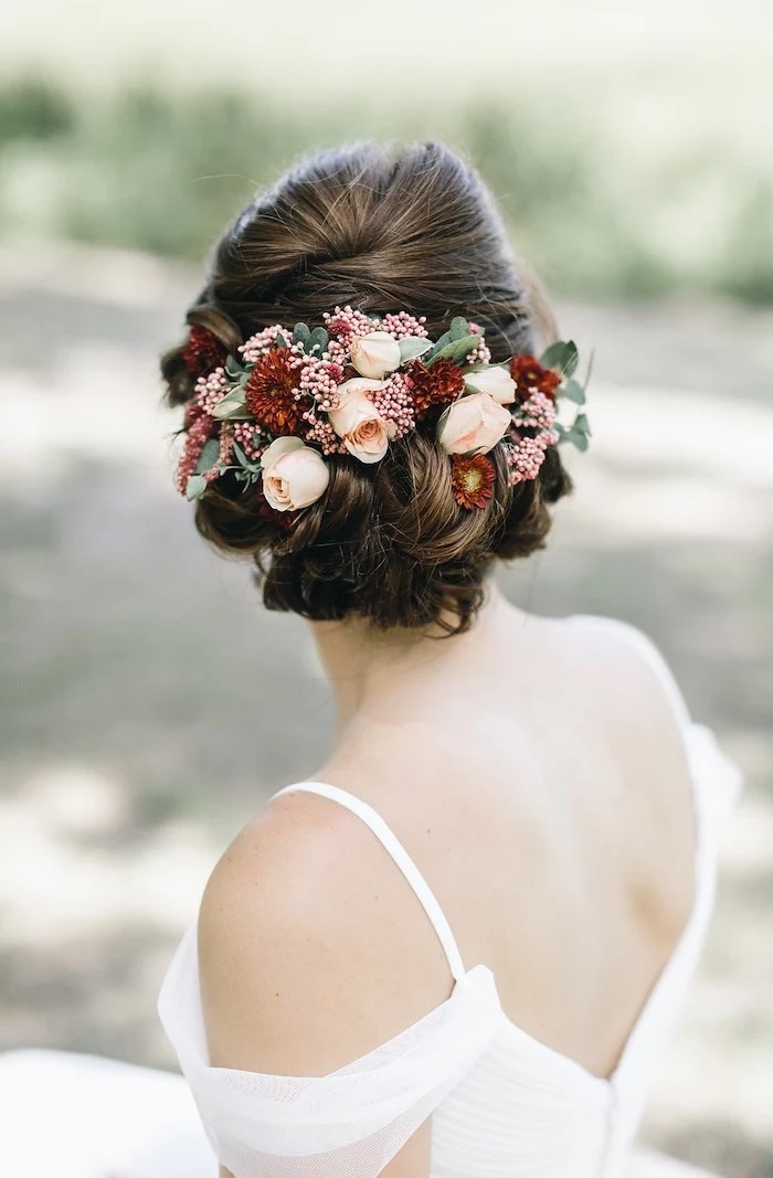 bridesmaid hairstyles, brown hair in a low updo, flower hair accessory, white dress
