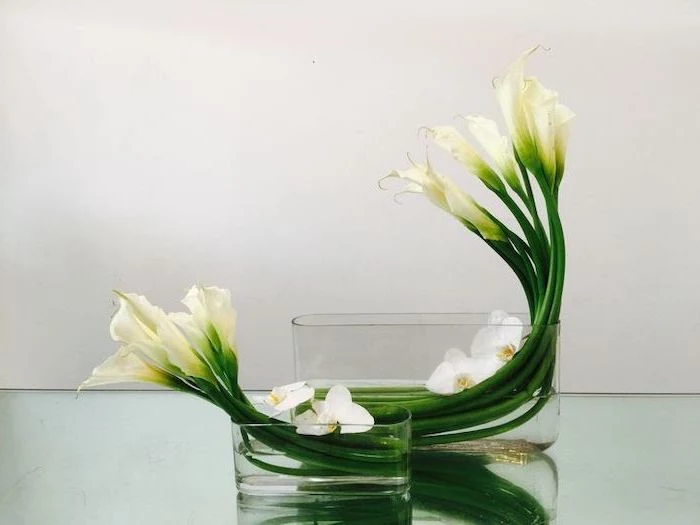 white flowers, in a bathtub like vases, flower art, flower arrangements ideas, on a glass countertop