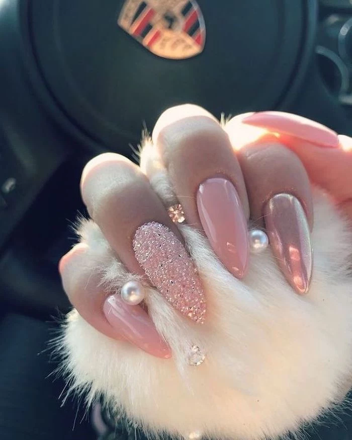 pink nail polish, pink glitter nail polish, long stiletto nails, cute easy nail designs, hand holding a white fur ball
