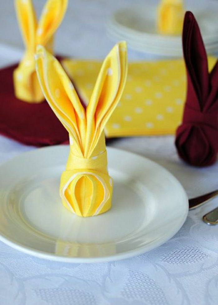 yellow napkins with white dots, on a white plate, easter table decorations centerpieces, burgundy napkins