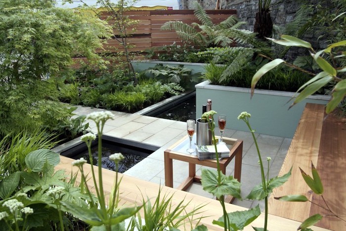 small ponds, cement tiles over it, wooden benches, surrounded by planted bushes and trees, small space gardening