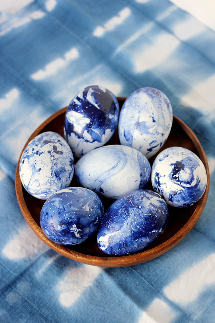 blue marble eggs, in a wooden bowl, on a blue cloth, easter egg ideas, diy tutorial