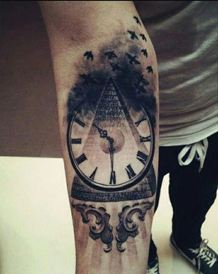 clock over a pyramid, tattoo ideas with meaning, forearm tattoos, man wearing a grey shirt, black pants