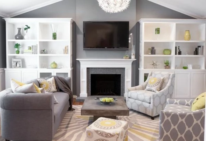 white bookshelves, grey couch living room, white and grey armchairs, yellow accents around the room