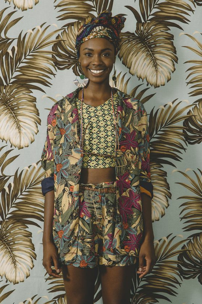 floral wallpaper, woman smiling, wearing a blazer, shorts and crop top, african print dresses, patterned headscarf