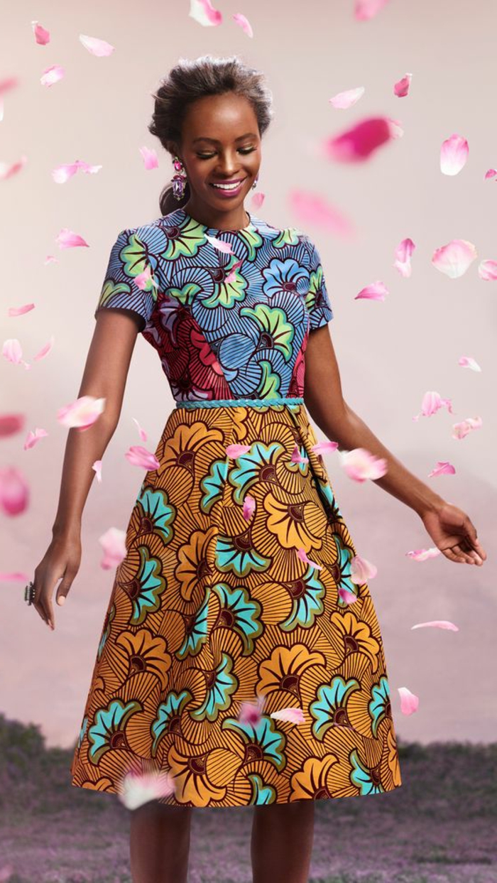 rose petals floating in the air, african print, mid length dress, woman smiling, blue belt