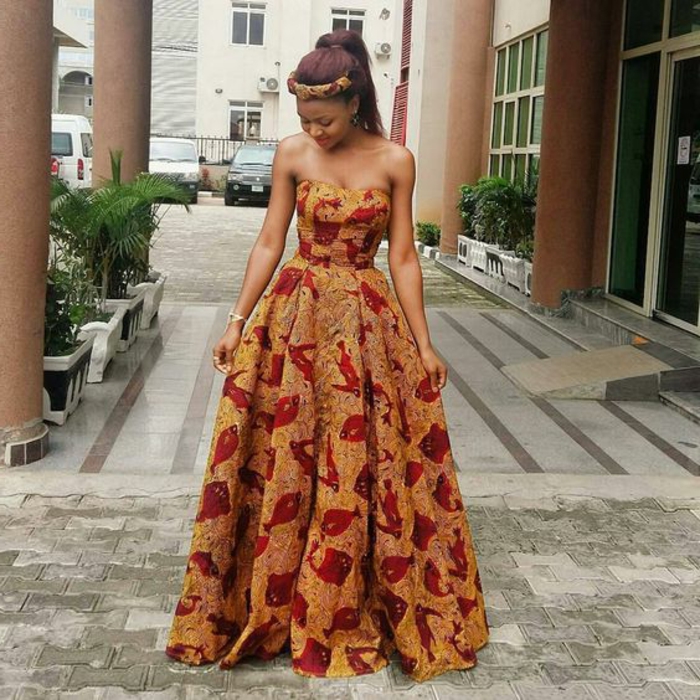 african print dresses, bare shoulders, woman wearing a long dress, standing on a paved street