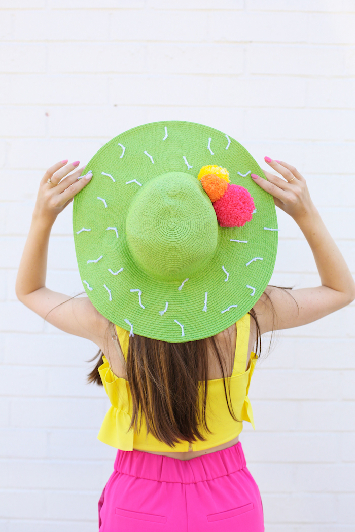 green hat, pink orange and yellow pom poms, white yarn, diy christmas gifts for mom, pink trousers