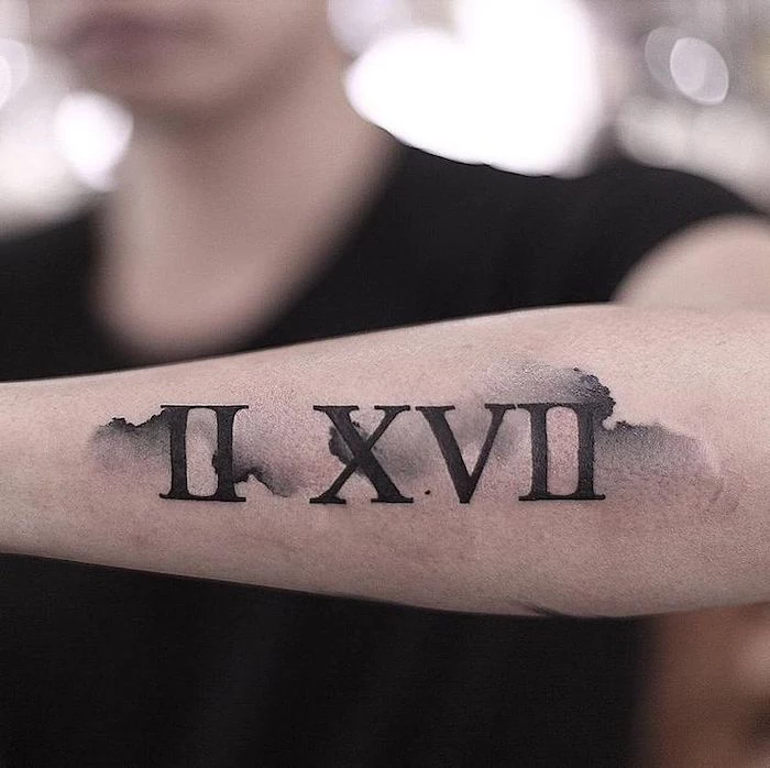 birthday in roman numerals, back of arm tattoo, black top