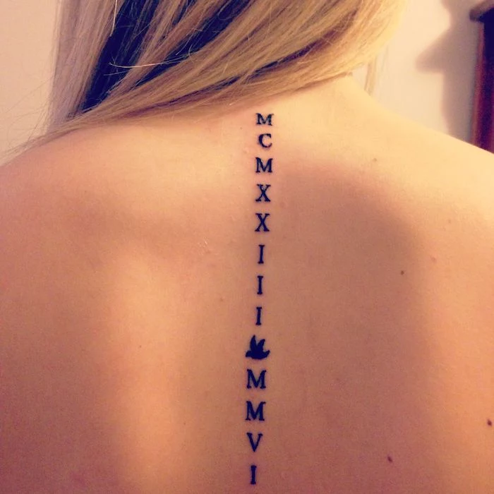 tattoo along the spine, blonde hair, roman numeral tattoo, white background