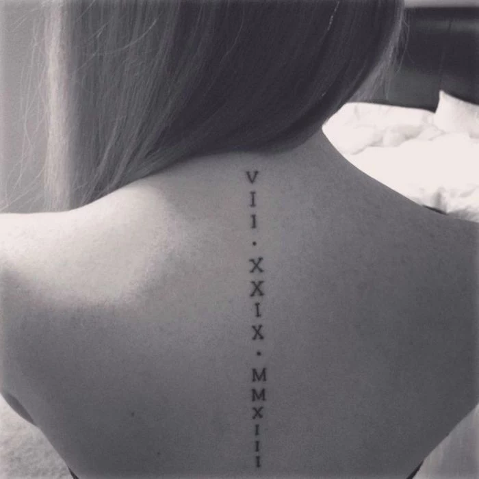 back tattoo, along the spine, black and white photo, birthday in roman numerals