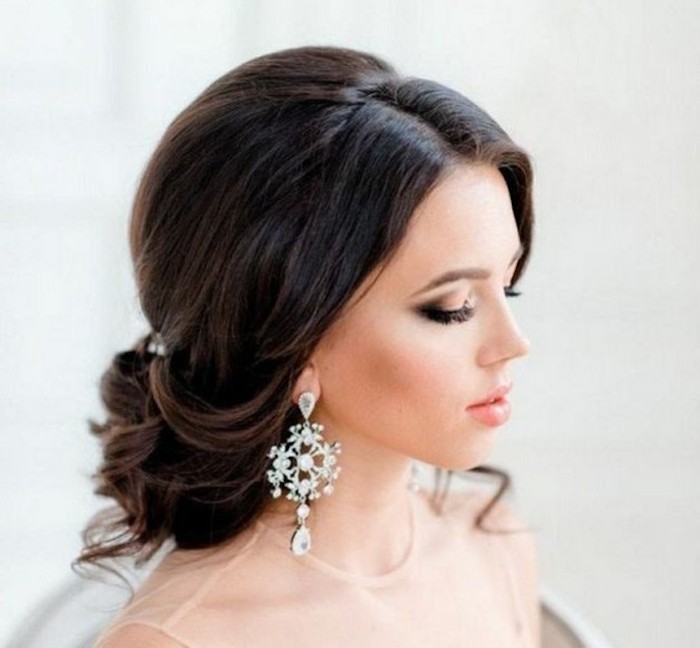 black hair in a low updo, long hairstyles for women, large white hanging earrings, beige tulle dress