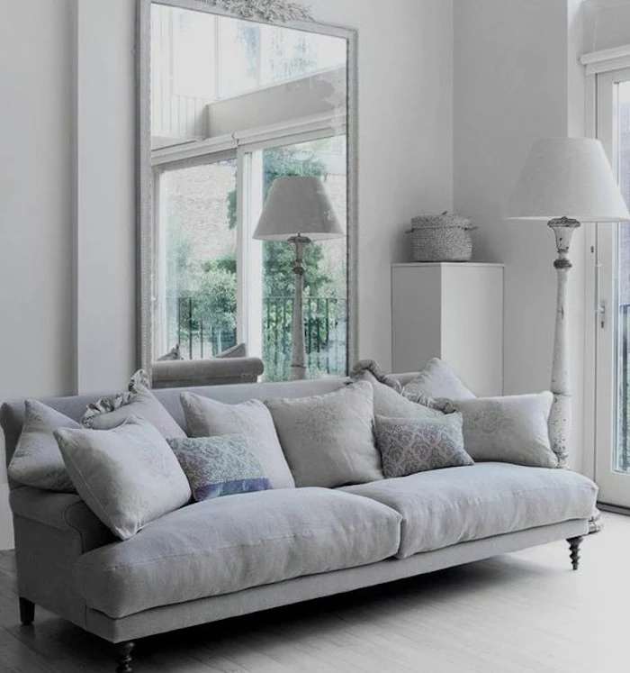 large mirror, grey couch living room, grey throw pillows, white walls, wooden floor