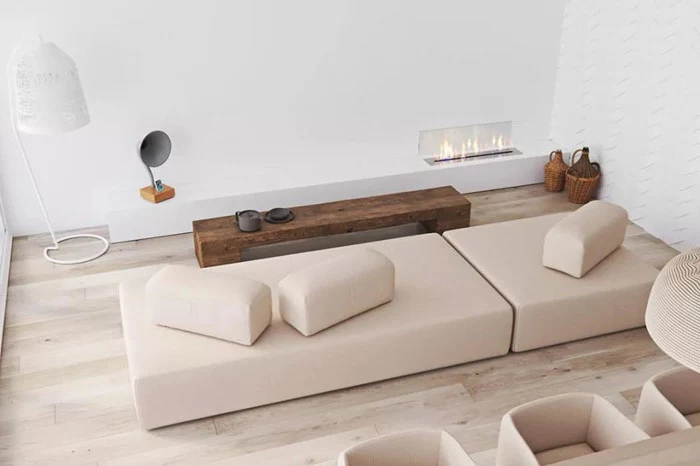 minimalist living room, electric fireplace, nude sofa, wooden floor, wooden bench, coffee table
