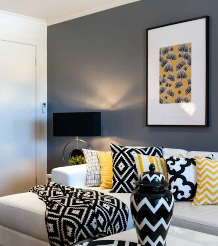 white sofa, grey wall, yellow throw pillows, black blanket, colours that go with grey