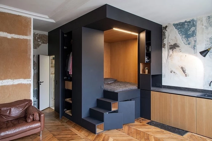 black box, serving as wardrobe and bed, minimalist living room, wooden floor, leather sofa