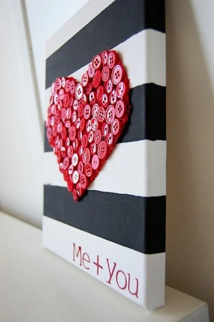 red buttons, forming a heart, unique wall decor, black and white striped, painted canvas, on a white table