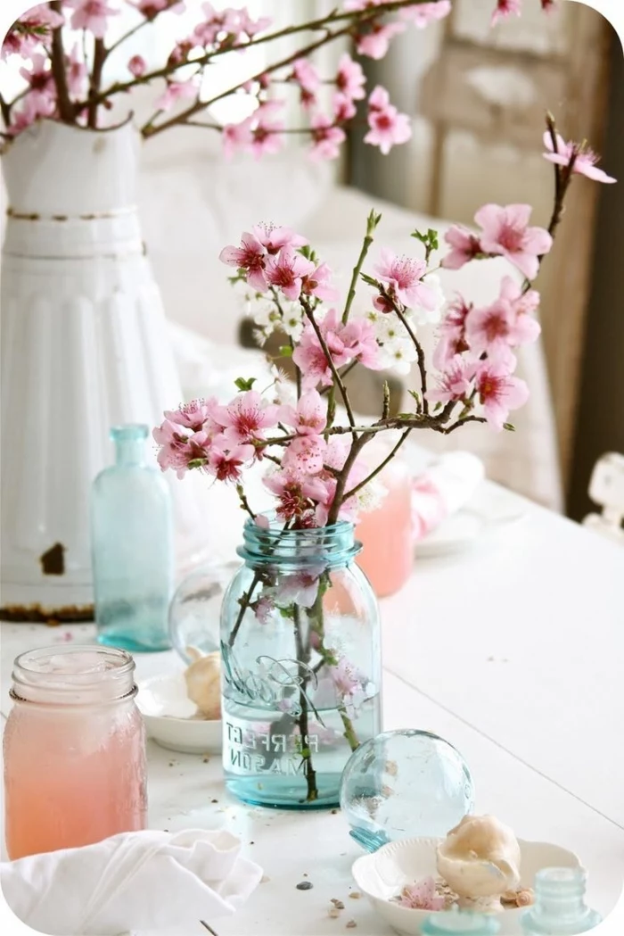 blossoming tree branches, blue mason jar, large white vase, table setting images, wooden white table