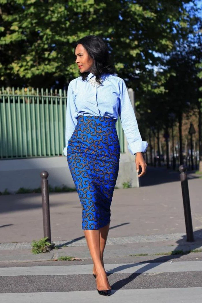 woman walking, wearing a blue shirt, blue skirt, african dresses, black heels, short black hair