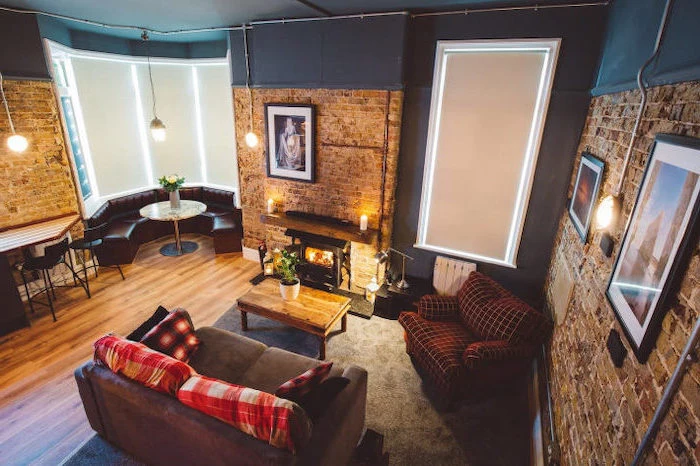 room design ideas, half brick, half blue walls, grey sofa, leather round sofa, wooden coffee table, industrial style