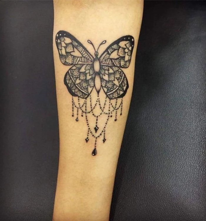 butterfly forearm tattoo, lotus mandala tattoo, black leather background