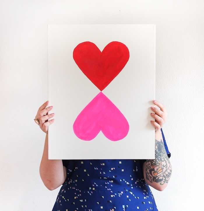 red and pink heart, painted on a white canvas, diy wall art, woman in a blue dress, holding a picture