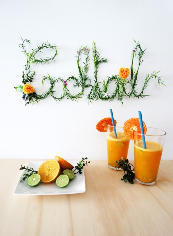 cocktail sign, living room wall decor ideas, two glasses, of orange juice, on a wooden table