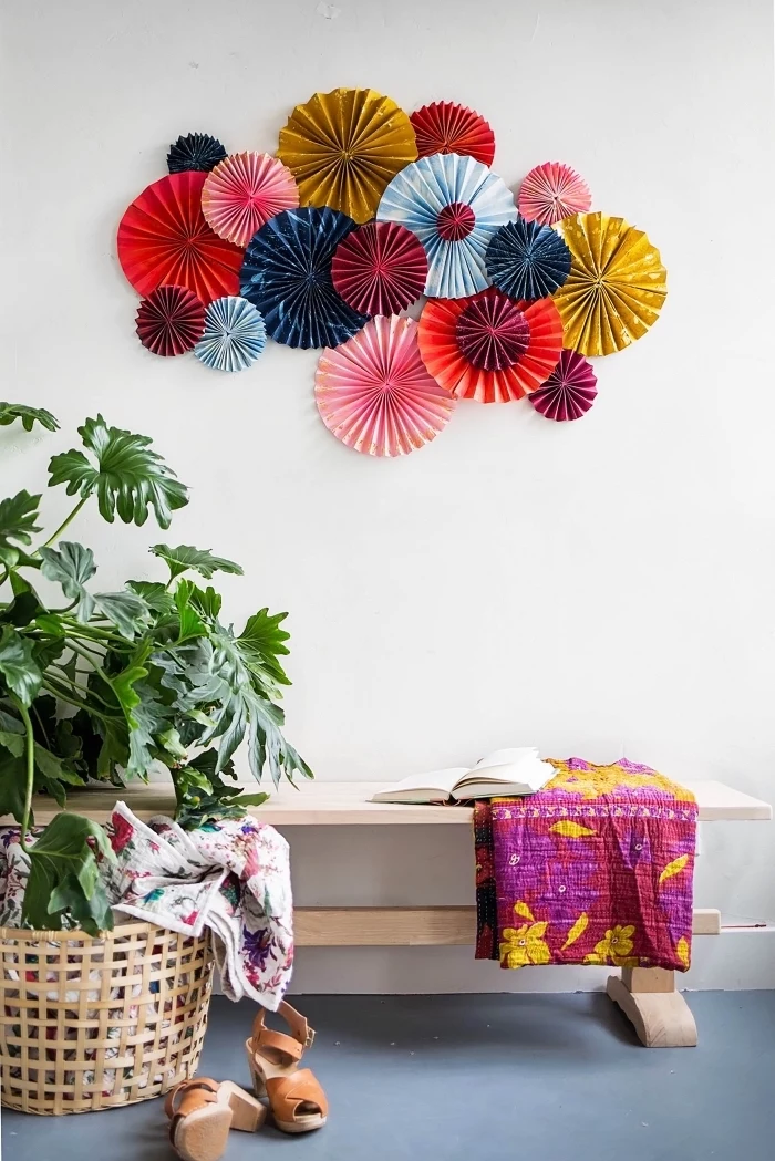 colourful paper fans, arranged together, over a wooden bench, girl room decor ideas, blue floor