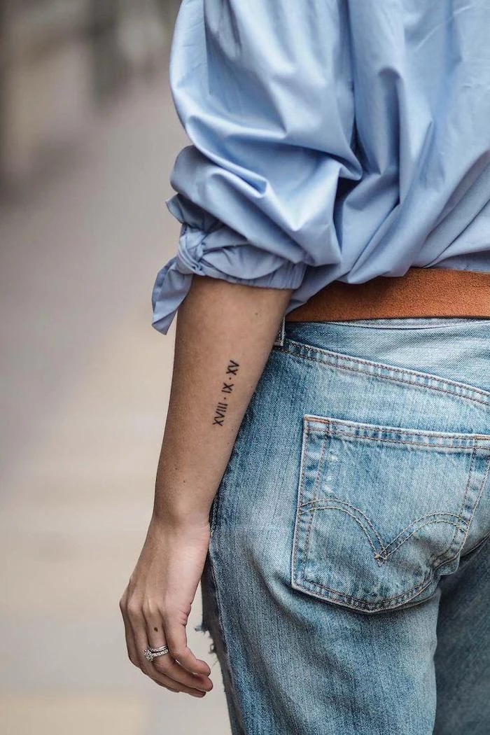 blue shirt and jeans, side arm tattoo, roman numeral tattoo ideas