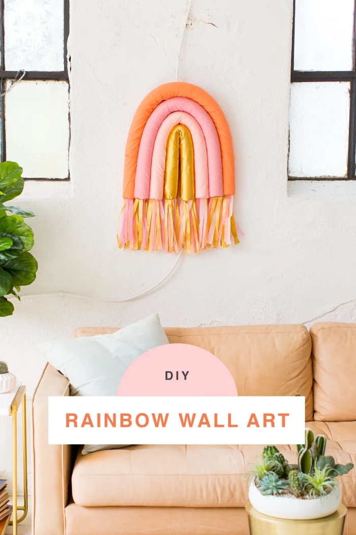diy rainbow wall art, living room wall decor ideas, orange sofa, light blue throw pillows, white wall
