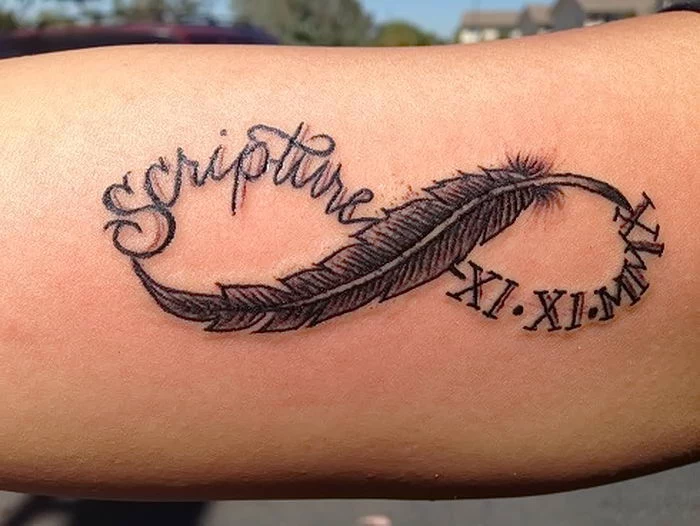 date in roman numerals, infinity symbols, feather and roman numerals, inside arm tattoo