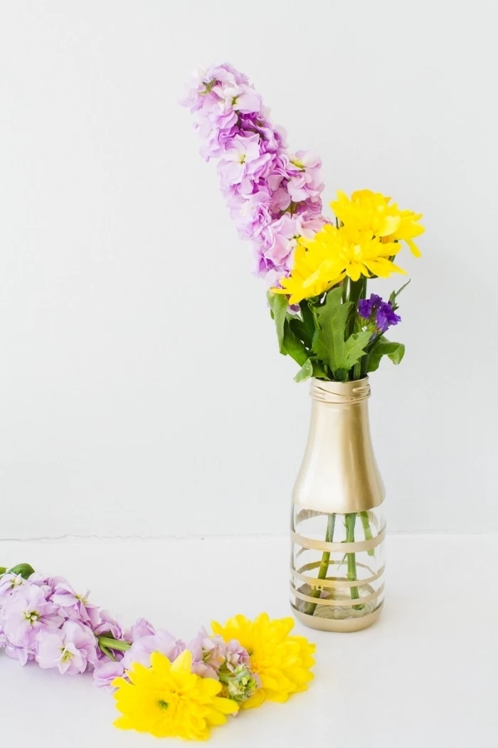 white background, dining room centerpieces, glass bottle, painted in gold, flower bouquets