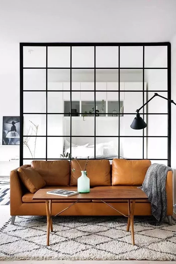 glass divider, brown leather couch, living room furniture for small spaces, white and grey carpet