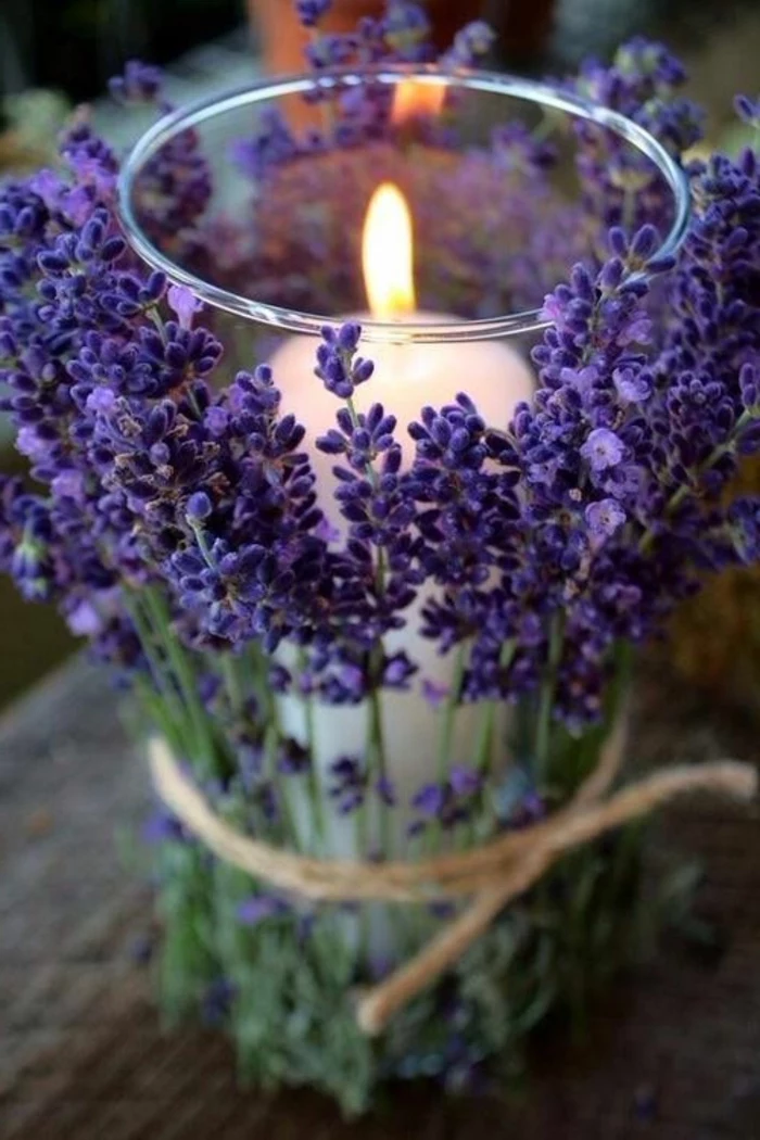 candle inside a glass, covered in lavender, wooden table, kitchen table decor, rustic style