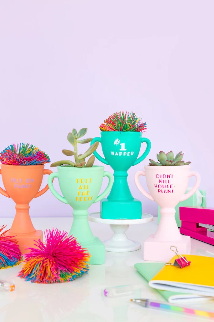colourful trophies, unique gifts for boyfriend, colourful pom poms, white cake stand, purple background