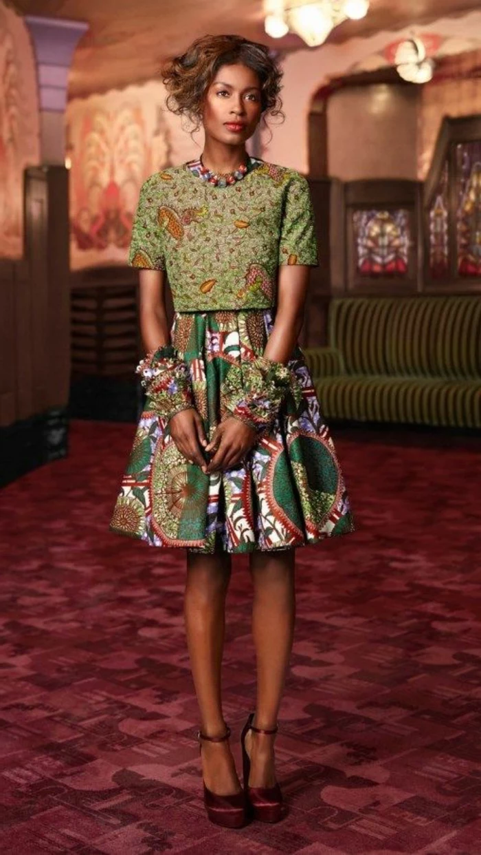 red carpet, woman wearing a skirt and a crop top, african dresses, brown hair in a low updo