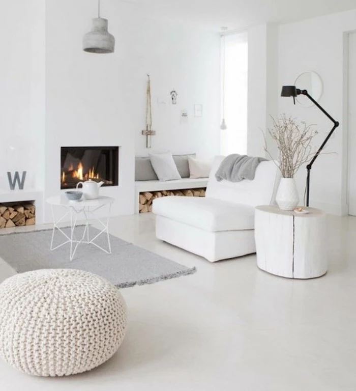 gray living room waves, white armchair and ottoman, grey rug, small white metal, coffee table, wooden side table