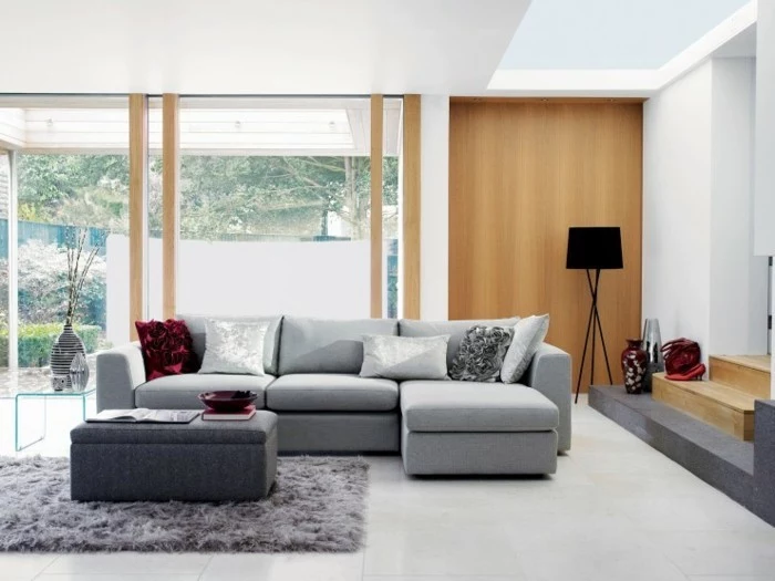 grey furry blanket, grey corner sofa, white tiled floor, gray living room walls, grey ottoman