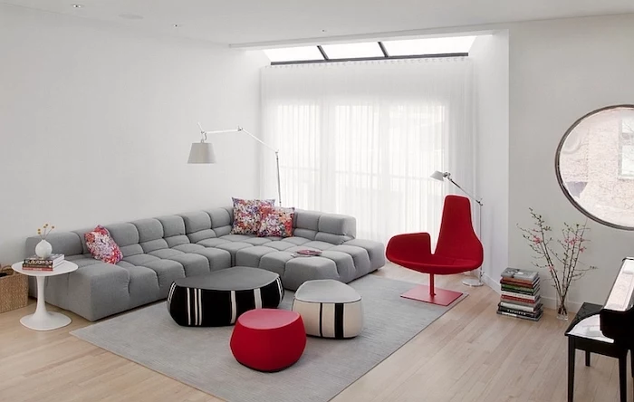 grey corner sofa, grey rug, red armchair, how to decorate a living room, red black and white ottomans