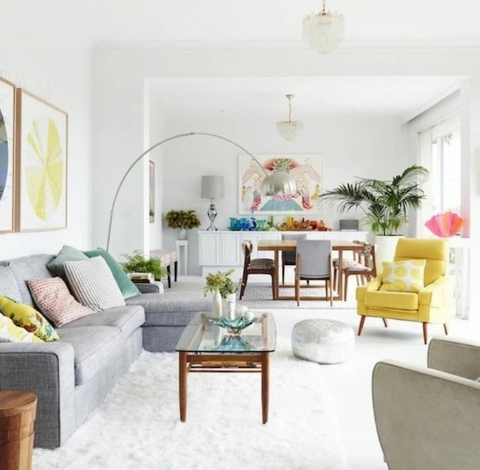 white walls, grey color schemes, grey sofa, yellow armchair, glass coffee table, white carpet