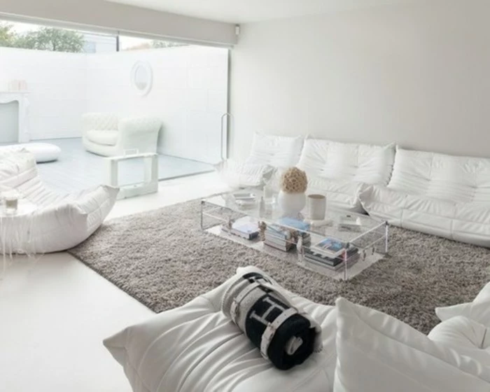 white sofas and armchair, glass coffee table, grey color schemes, large grey carpet, large window