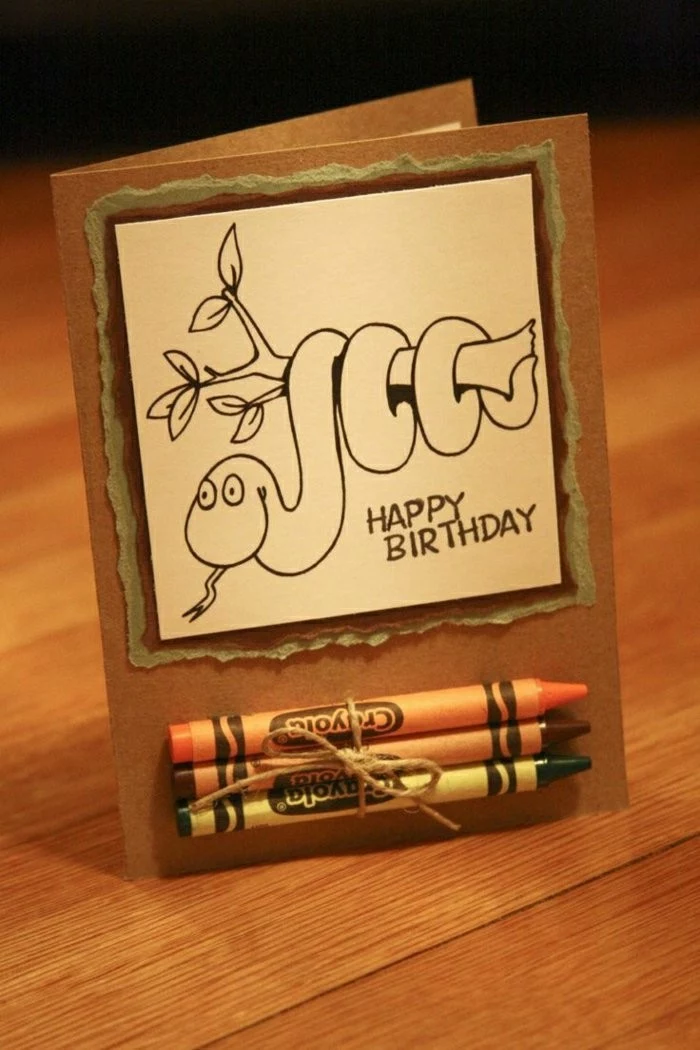 snake around a tree branch, crayons glued to the card, happy birthday card ideas, wooden table