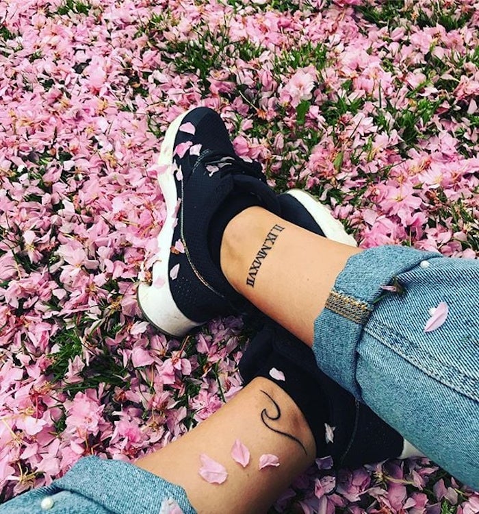pink flower petals, black sneakers, ankle tattoos, side arm tattoos